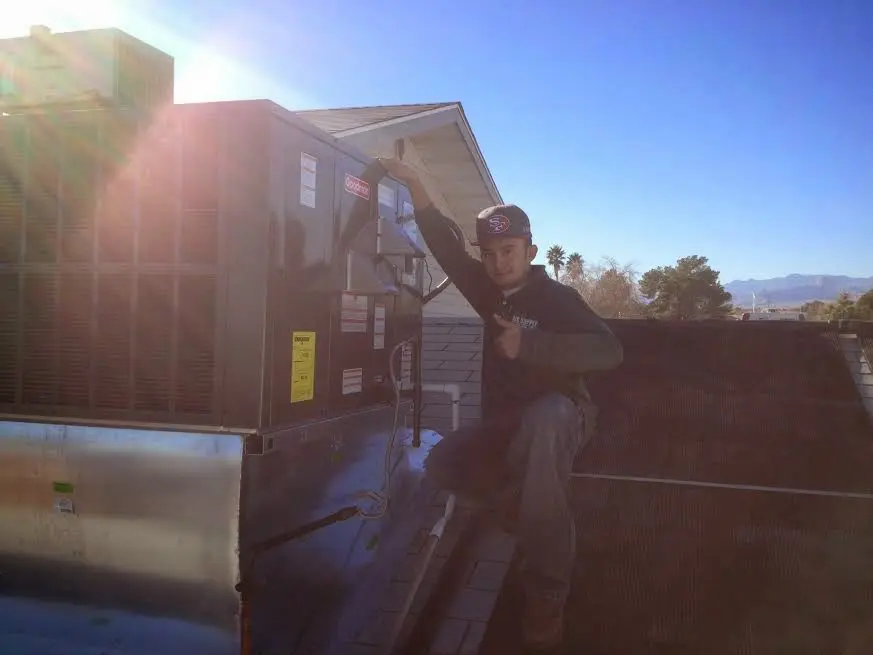 HVAC technician performing Heat Pump Repair on a rooftop unit in Aiken